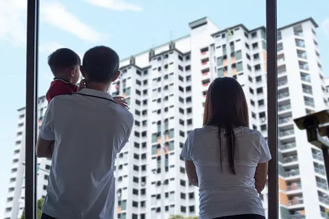 familia mira por ventanal edificio de pisos
